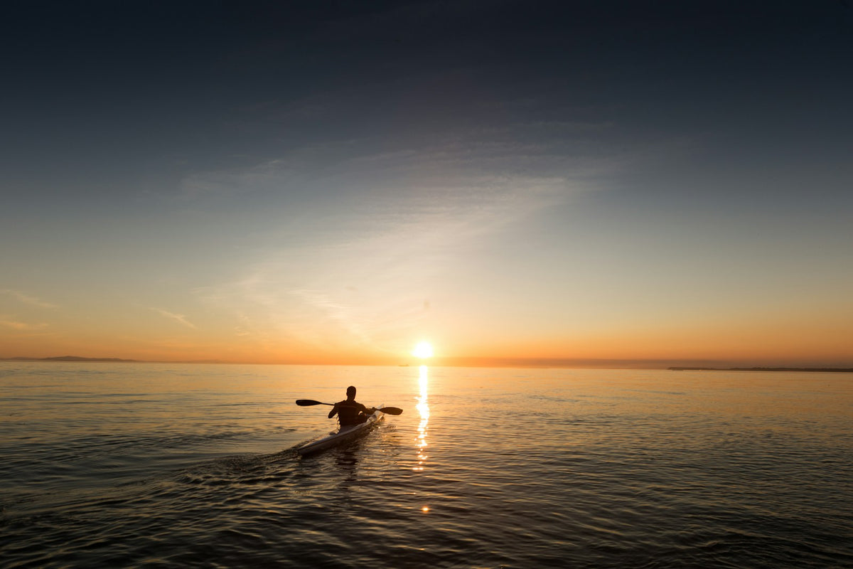 Kayaks resting on calm water near the shore